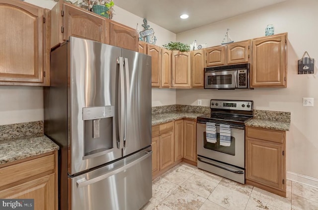 kitchen featuring light stone counters, recessed lighting, and stainless steel appliances