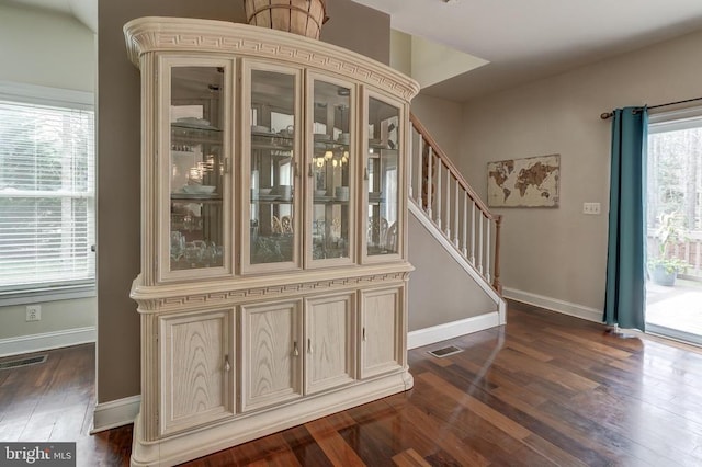 foyer featuring dark wood-style floors, visible vents, and baseboards
