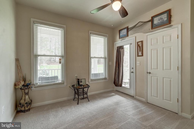 entryway featuring carpet, baseboards, and ceiling fan