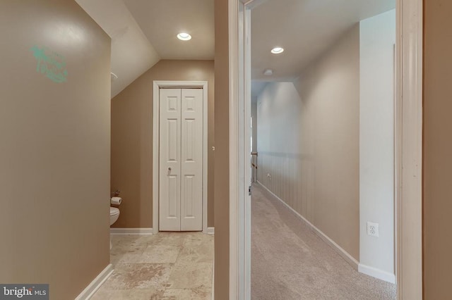 hallway with light colored carpet, lofted ceiling, recessed lighting, and baseboards