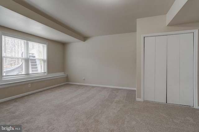 unfurnished bedroom featuring a closet, carpet flooring, and baseboards