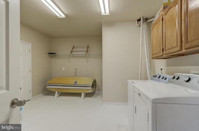 laundry area featuring baseboards, cabinet space, and independent washer and dryer
