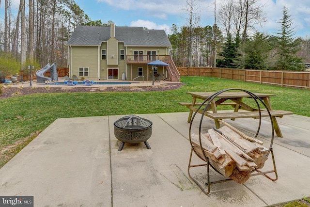 rear view of house with a patio, a fenced backyard, stairway, a fire pit, and a wooden deck