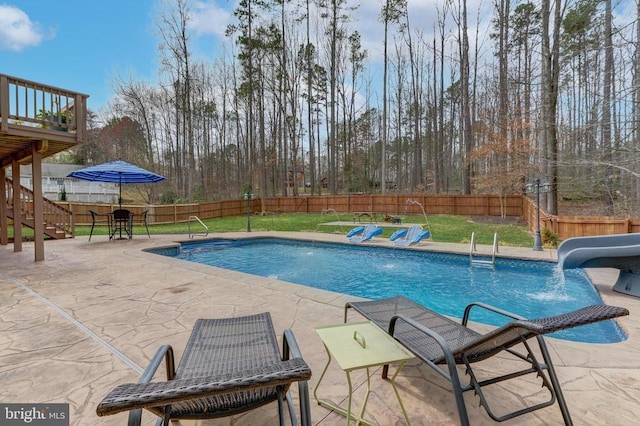 view of swimming pool with stairway, a fenced backyard, a fenced in pool, and a water slide