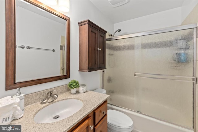 full bathroom with combined bath / shower with glass door, toilet, and vanity