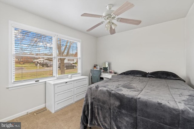 bedroom with baseboards, visible vents, a ceiling fan, and light carpet
