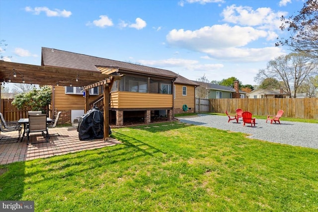 back of property with a fenced backyard, a yard, a patio, and a pergola