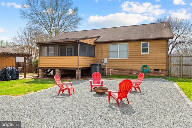 rear view of property featuring an outdoor fire pit, a sunroom, crawl space, and a patio area
