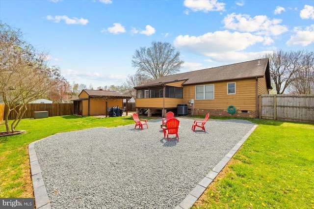 back of house with an outbuilding, a patio, a fenced backyard, crawl space, and a yard
