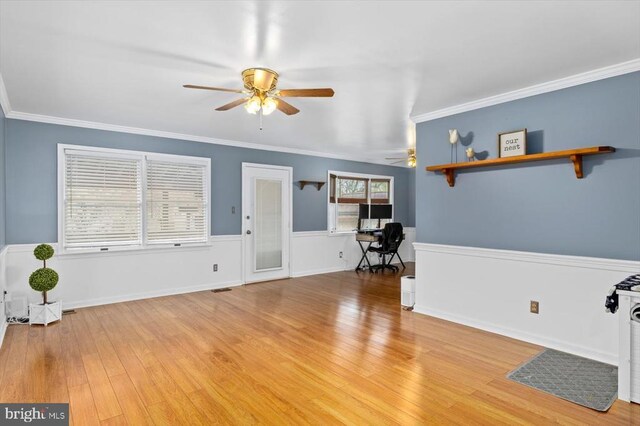 unfurnished living room featuring crown molding, a ceiling fan, and light wood finished floors