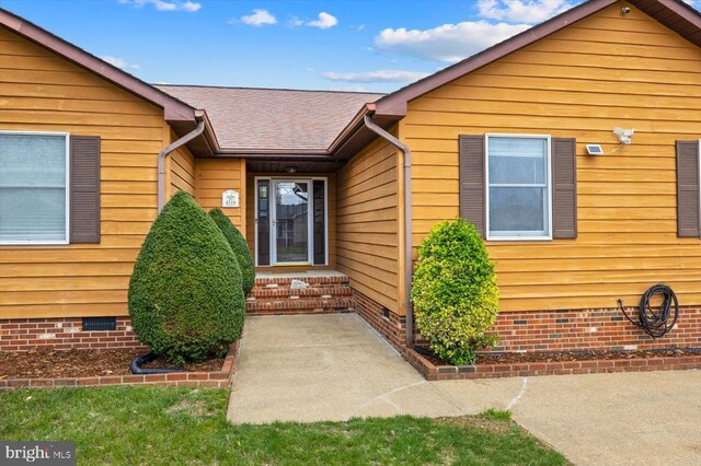 property entrance featuring crawl space and roof with shingles