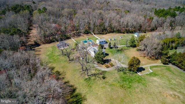 birds eye view of property featuring a forest view