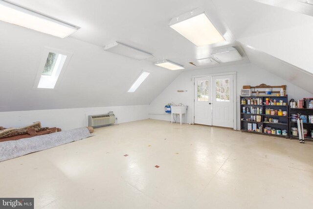 bonus room featuring lofted ceiling with skylight, concrete floors, and a sink