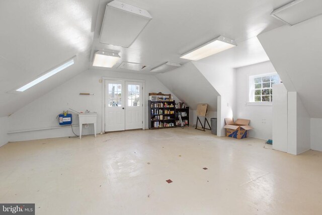 bonus room featuring lofted ceiling and concrete floors