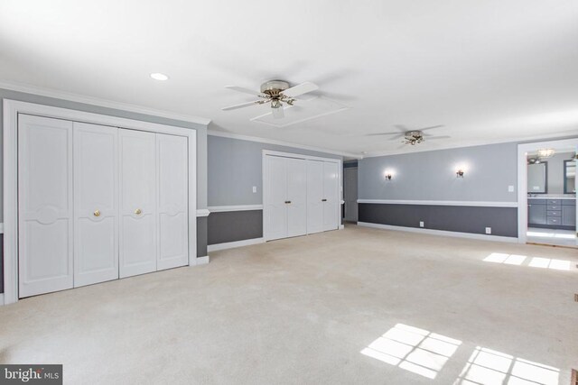 unfurnished living room with baseboards, ornamental molding, a ceiling fan, and light colored carpet