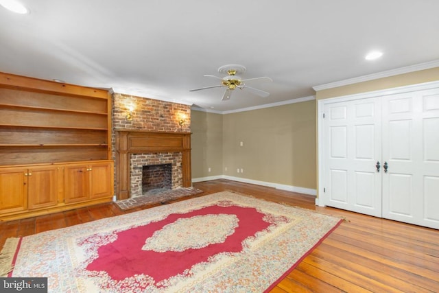 living room with ornamental molding, hardwood / wood-style flooring, a fireplace, and ceiling fan
