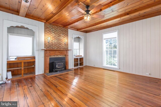 unfurnished living room featuring a wood stove, wood ceiling, and wood-type flooring