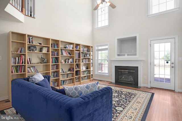 living room with a towering ceiling, hardwood / wood-style flooring, and plenty of natural light