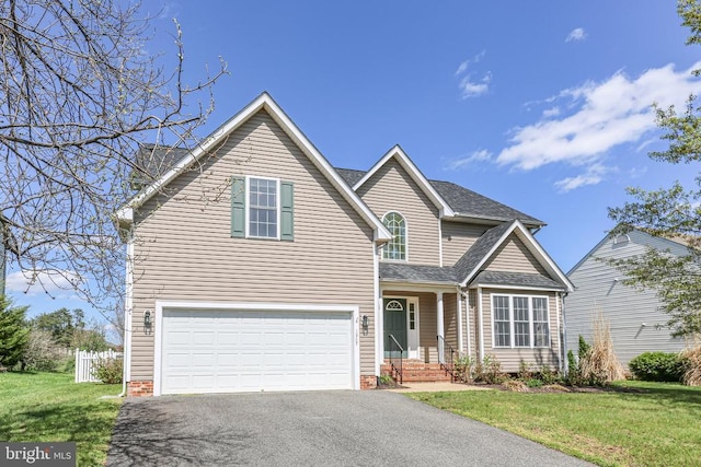 traditional-style home featuring a garage, fence, driveway, and a front yard