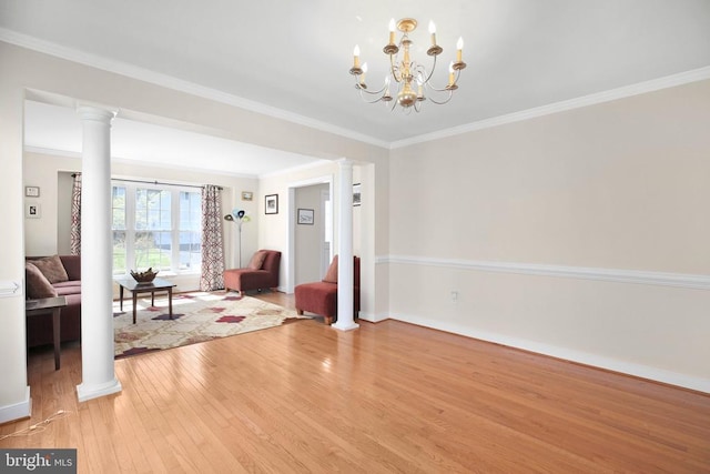 unfurnished living room with light wood-style flooring, baseboards, ornamental molding, ornate columns, and a notable chandelier