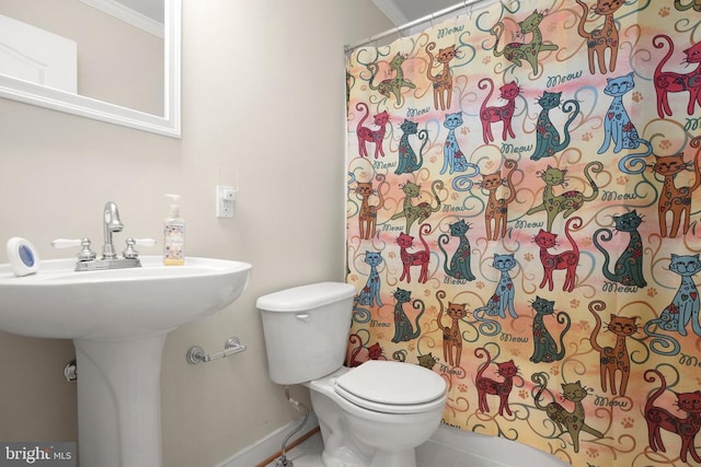 full bath with a sink, baseboards, toilet, ornamental molding, and tile patterned floors