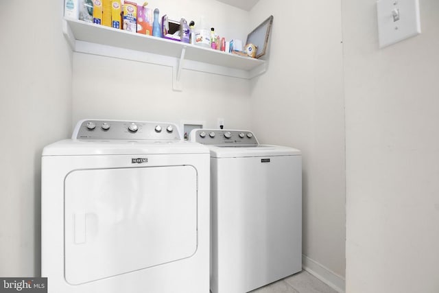 laundry area featuring washing machine and clothes dryer, laundry area, and baseboards
