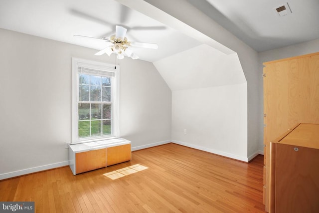 bonus room with lofted ceiling, visible vents, baseboards, light wood-type flooring, and a ceiling fan