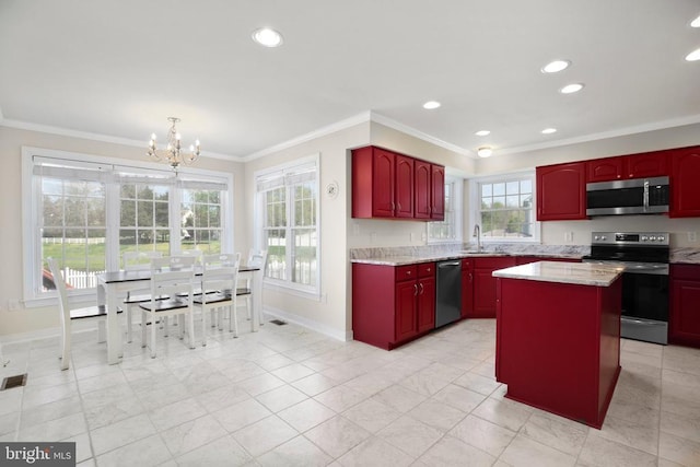 kitchen featuring a sink, a chandelier, stainless steel appliances, baseboards, and ornamental molding