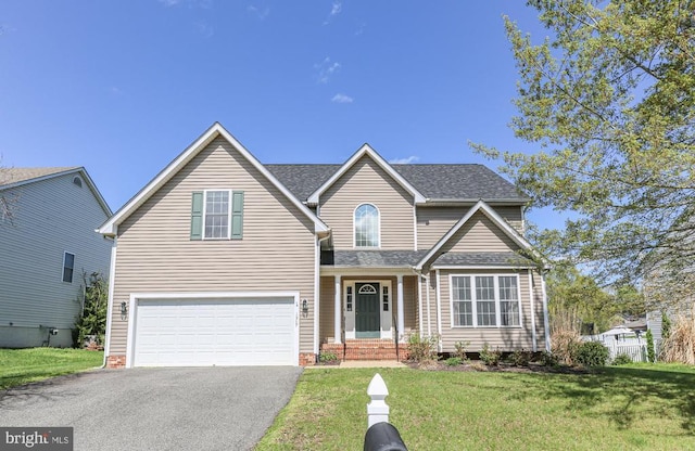 traditional-style house featuring a front lawn, aphalt driveway, a shingled roof, and an attached garage