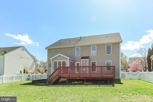 back of property with a deck, a gate, a fenced backyard, and a lawn