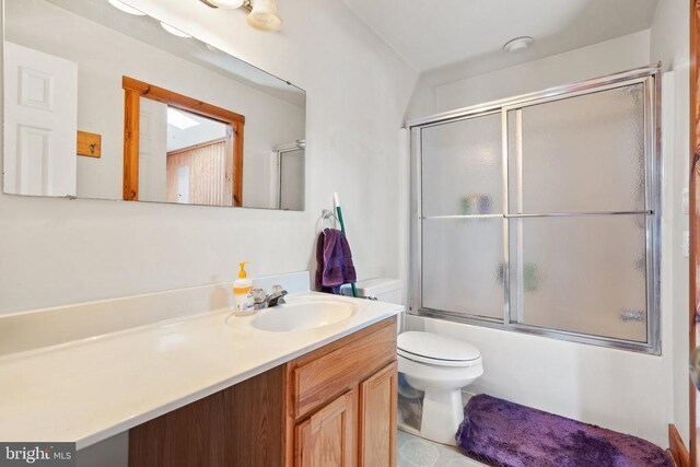 bathroom with vanity, bath / shower combo with glass door, and toilet