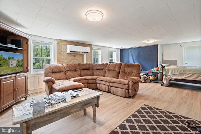 living area with a wall mounted AC and light wood finished floors