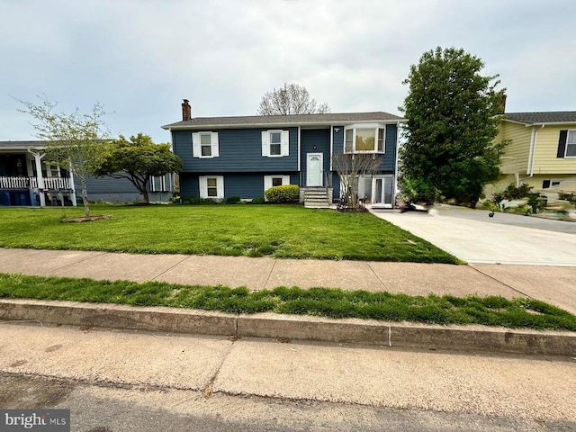 - raised ranch with entry steps, a front lawn, and a chimney