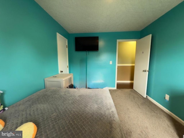  - unfurnished bedroom featuring a textured ceiling, carpet flooring, and baseboards