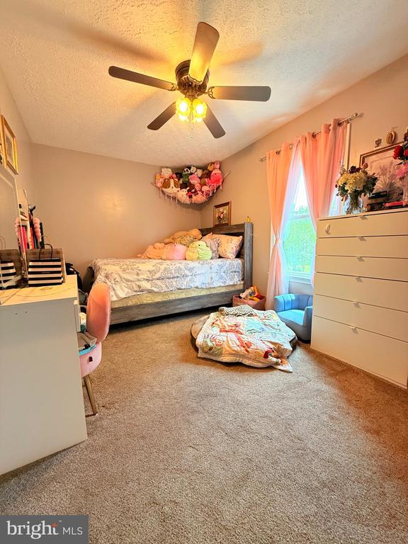  - bedroom with a textured ceiling, carpet, and ceiling fan