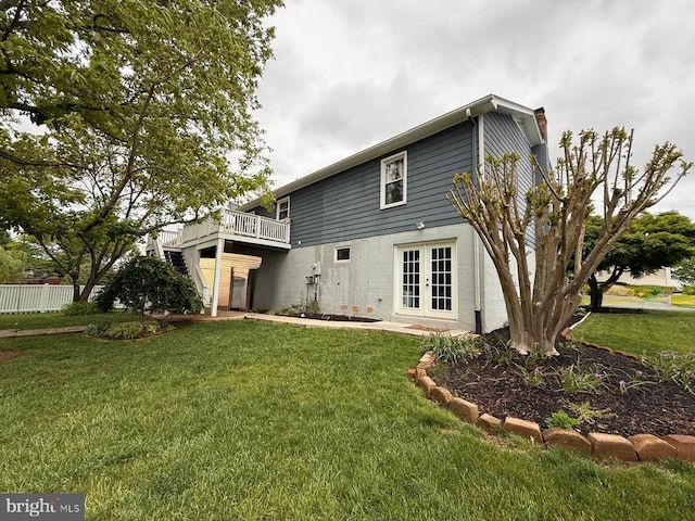  - rear view of property featuring french doors, a chimney, and a yard