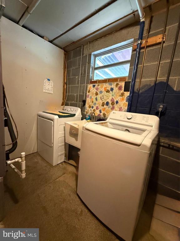  - laundry room featuring separate washer and dryer and concrete block wall