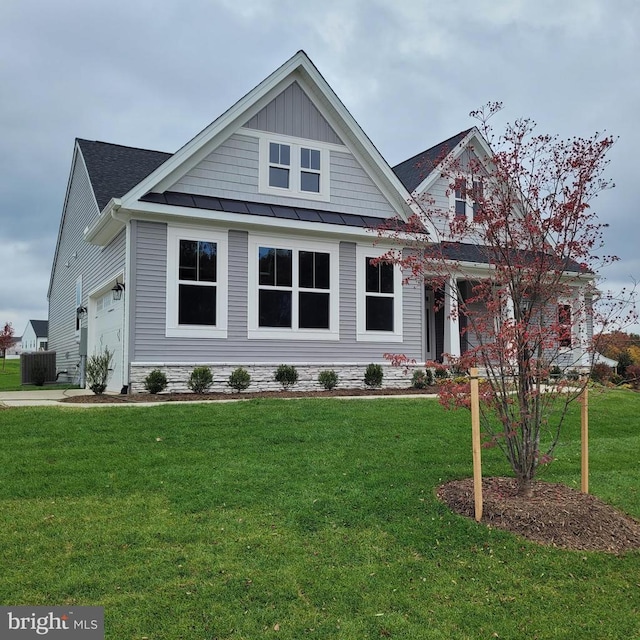 view of front of home with a front lawn, a standing seam roof, metal roof, and a garage