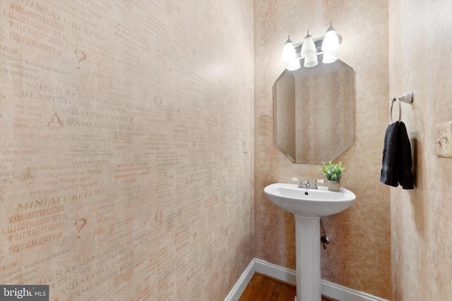 bathroom with baseboards and wood finished floors