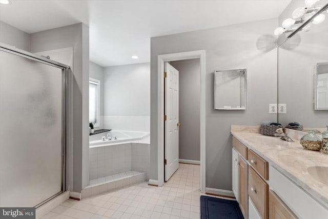 bathroom with a bath, a stall shower, baseboards, double vanity, and tile patterned floors