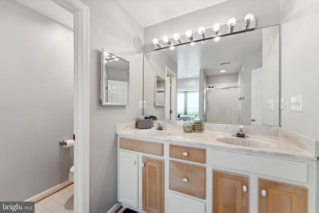 full bathroom with toilet, a stall shower, double vanity, tile patterned flooring, and baseboards