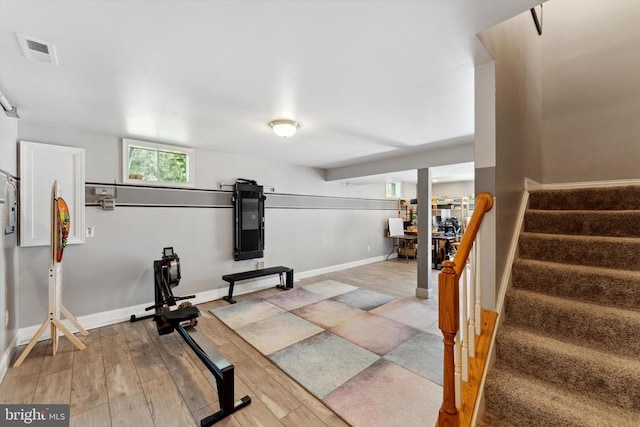 workout area featuring light wood-style flooring and baseboards