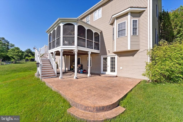 rear view of property featuring french doors, a patio, a sunroom, a yard, and stairway