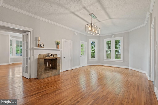105 E Washington St, Remington, VA 22734 - unfurnished living room with a fireplace, light wood-style flooring, a chandelier, a textured ceiling, and crown molding