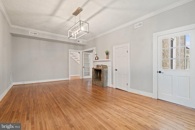 105 E Washington St, Remington, VA 22734 - unfurnished living room with ornamental molding, stairs, light wood-style floors, a chandelier, and a textured ceiling