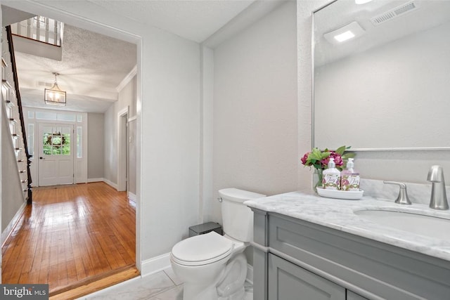 105 E Washington St, Remington, VA 22734 - half bath featuring vanity, a textured ceiling, and wood finished floors