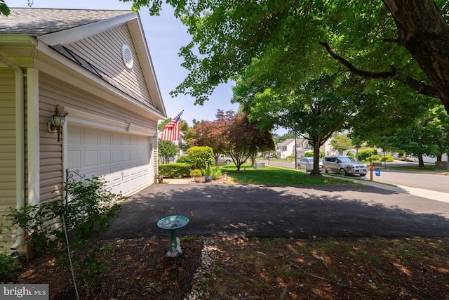 view of yard with driveway and a garage