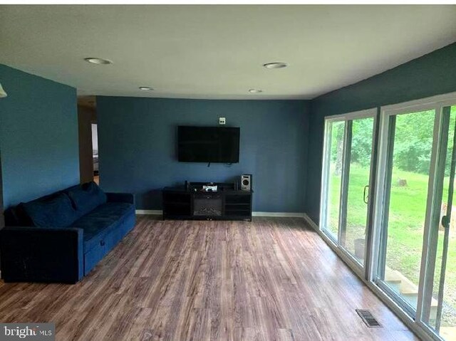 unfurnished living room featuring wood finished floors, baseboards, and recessed lighting
