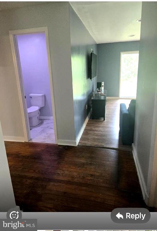 corridor featuring wood finished floors and baseboards