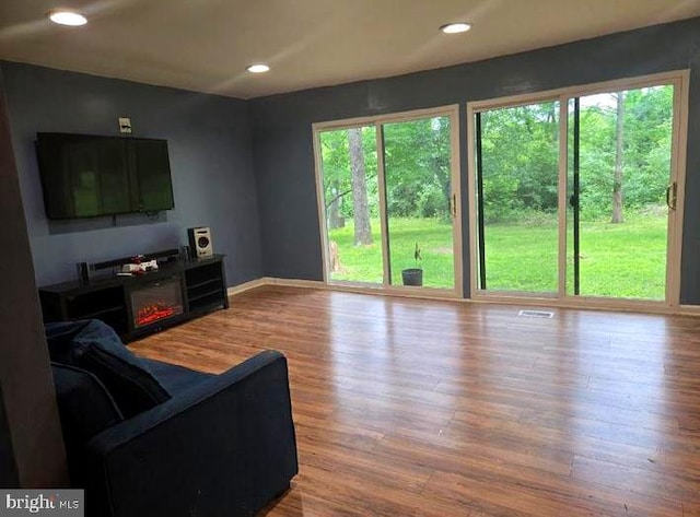 living area featuring wood finished floors, recessed lighting, and baseboards